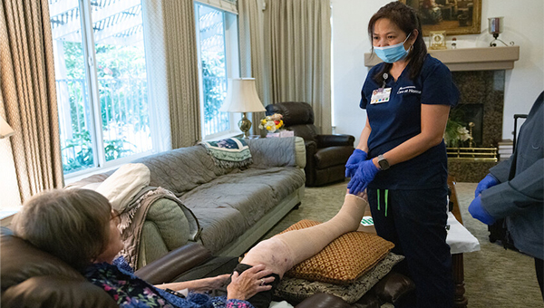 Nurse tending to patient in home