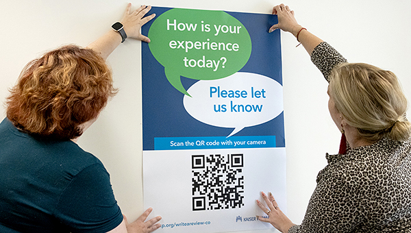 2 women hanging up a poster