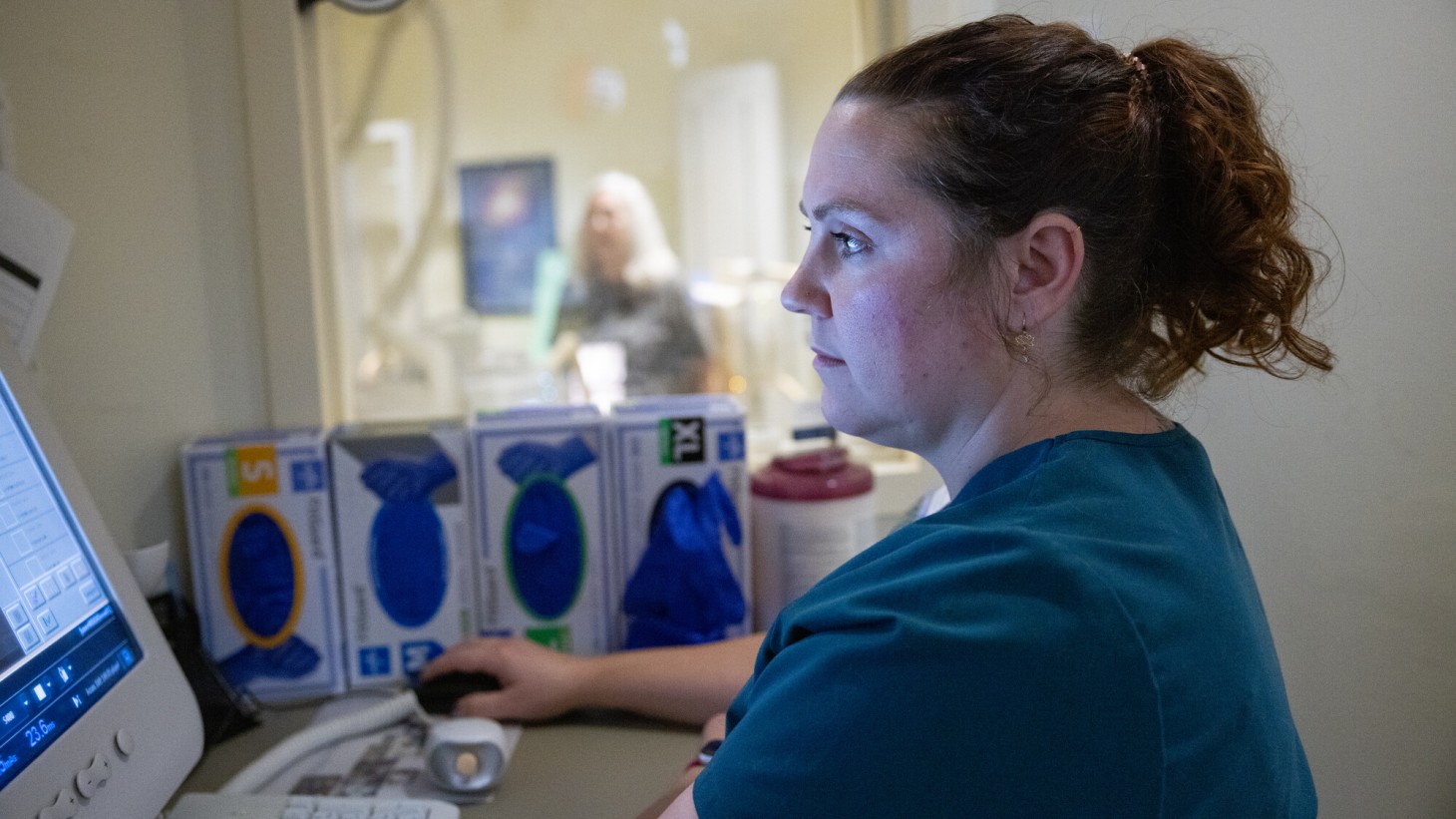 A female radiologic technologist views files on her computer