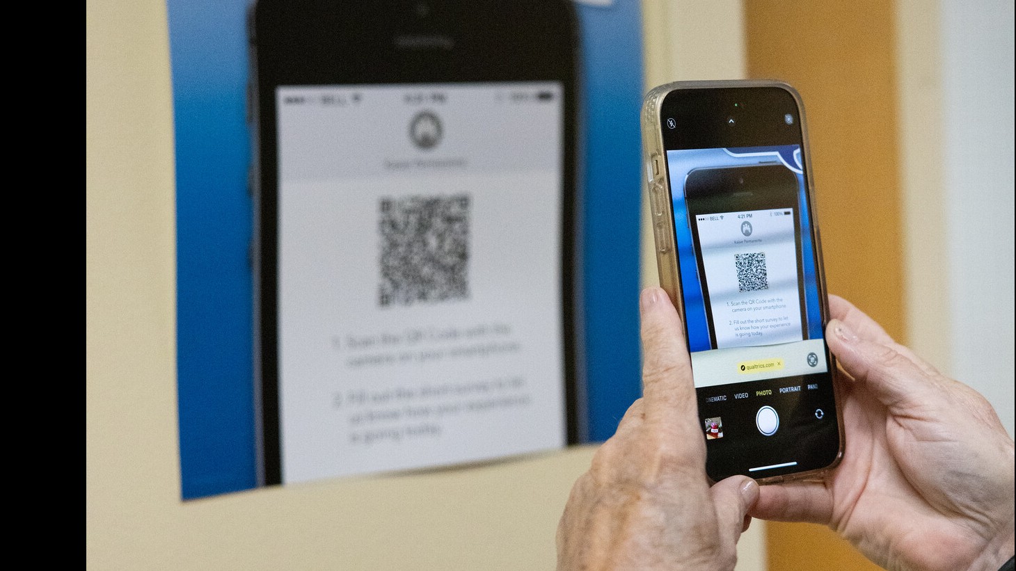 A phone is pointing at a poster with a QR code