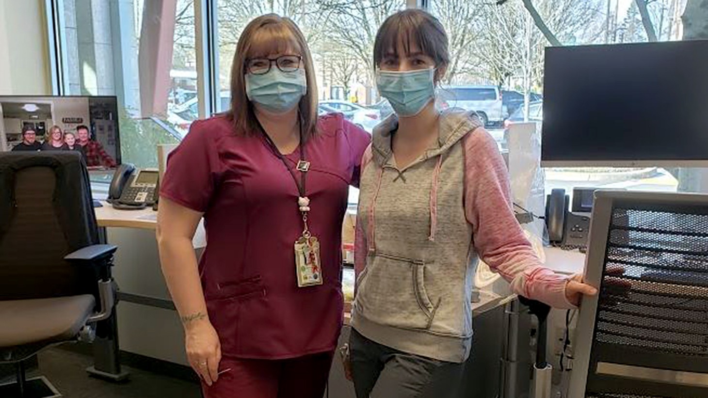 Two women, health care workers, posing together in an office